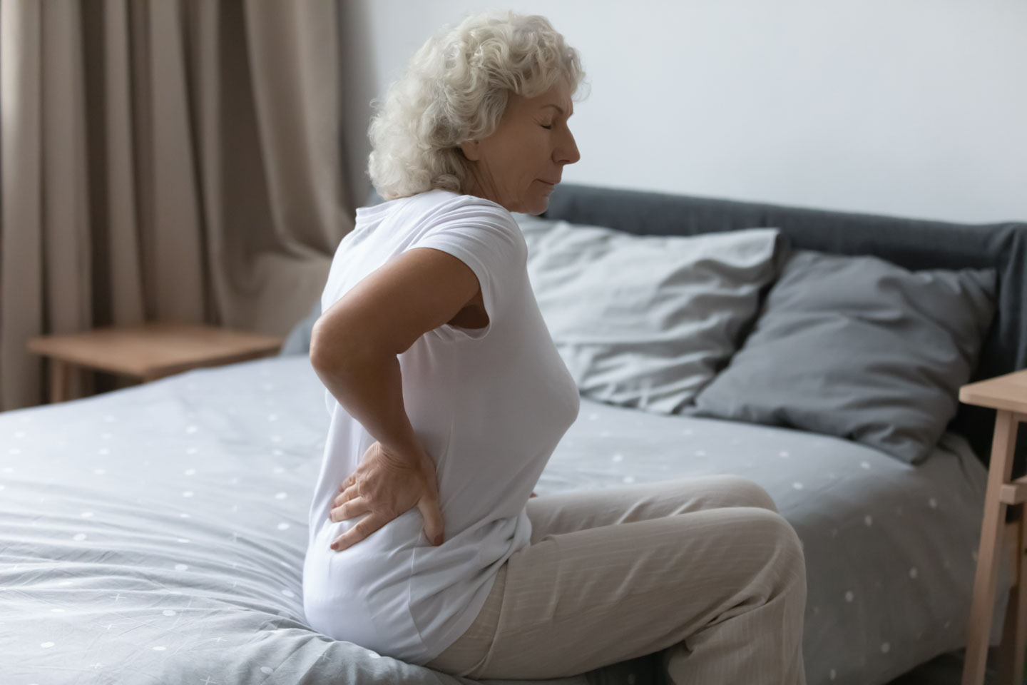 woman with lumber back pain on bed